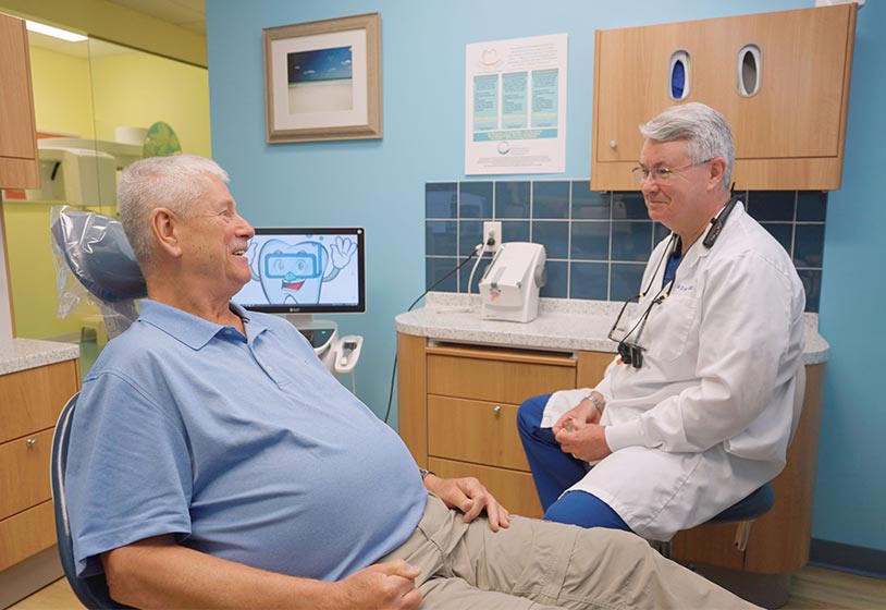 Dr. Bedich speaking to patient in dental chair about dental treatment